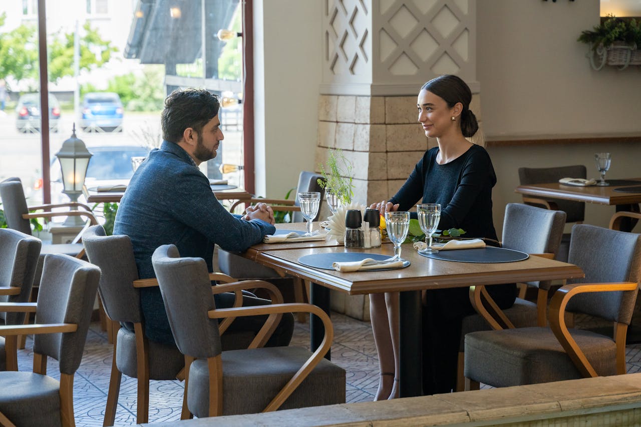 A man and woman enjoying a romantic meal in a cozy café setting, exuding warmth and connection.